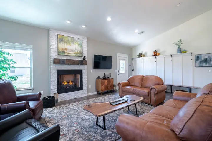 Spacious living room with a gas fireplace, leather sofas and a live-edge coffee tables. Perfect to settle in and unwind after a day outdoors
