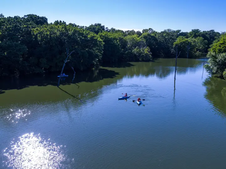 Lakefront property in Stratford, OK. Paddle kayaks across a calm, tree-lined private lake perfect for kayaking and fishing