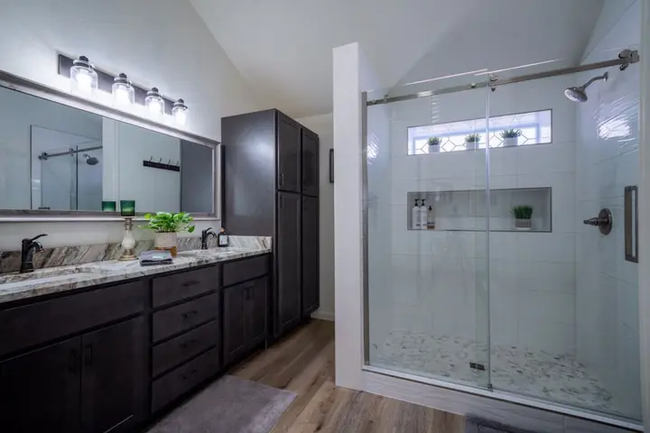 Bathroom with a long dark-wood vanity and a walk-in glass shower