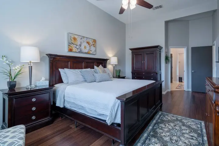 Bedroom with a cherry-wood king bed, matching nightstands and an armoire