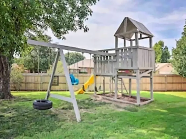 Outdoor playset for kids in a fully fenced yard for the dog